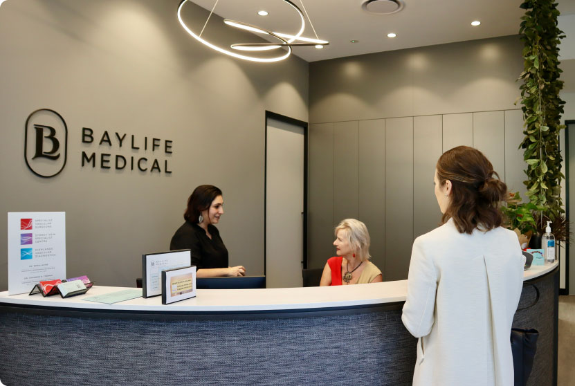 Woman booking appointment at front desk of Baylife Medical